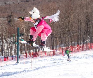 Image of snowboarder jumping on slope at New England ski resort.