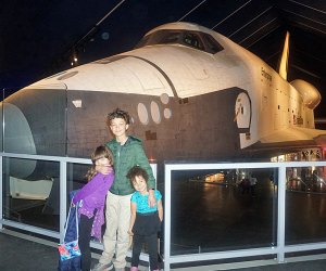 Three kids in front of the Space Shuttle Enterprise at the Intrepid, a space museum near NYC