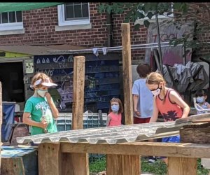 Masked children play in The Yard, Governors Island's adventure playground