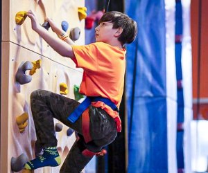 Image of child climbing rock wall at Urban Air Adventure Park in Connecticut.