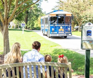 Things To Do in Williamsburg, VA with Kids: Family waiting for trolley in historic Yorktown