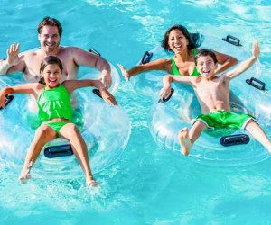 Photo of adults and children on water floats in a giant pool.