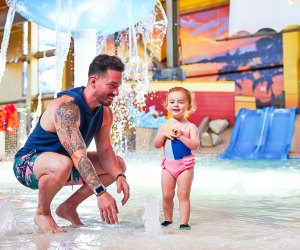 Photo of adult and child at indoor splash pad.