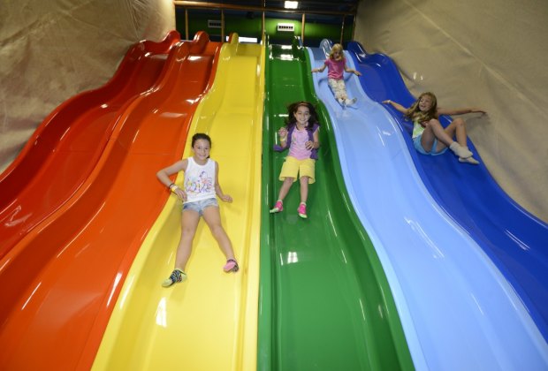 kids sliding down a rainbow slide