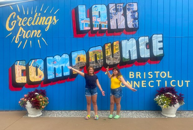 Photo of kids posing in front of Like Compounce sign