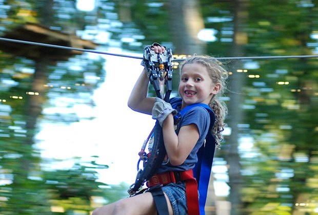 Mädchen lächelt beim Zip Lining bei Camelback Mountain Adventures