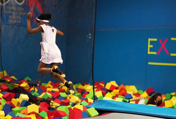 Girl jumping into a foam pit at a trampoline park near NYC