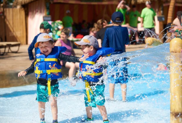 Photo of two kids getting splashed with water- Best Outdoor Water Parks