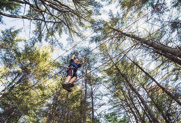 Boy walks across a tight rope at Cape May County Tree to Tree Adventure Park