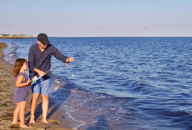 Photo of father and daughter fishing on a Cape Cod beach.