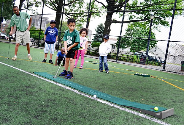 Children learn to play golf during the City Parks free summer sports programs in NYC