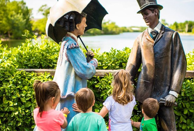 kids look at statues with a beautiful pond at the Grounds for Sculpture