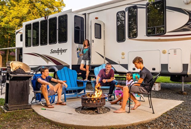 Ultimate Road Trip Planner: How to Have the Perfect Family Road Tripfamily rv camping sitting by a fire