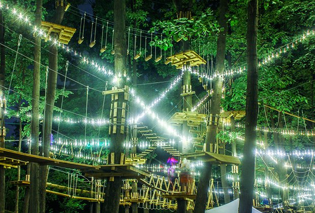 Der Adventure Park am Long Island's Course ist für einen glühenden nächtlichen Aufstieg beleuchtet's course is lit for a glowing nighttime climb