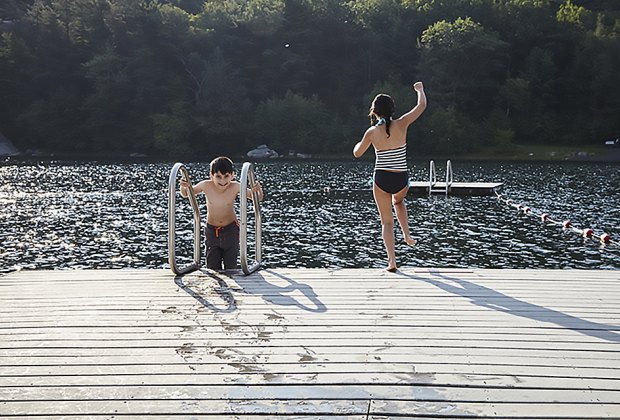 kids jumping off a dock into a lake