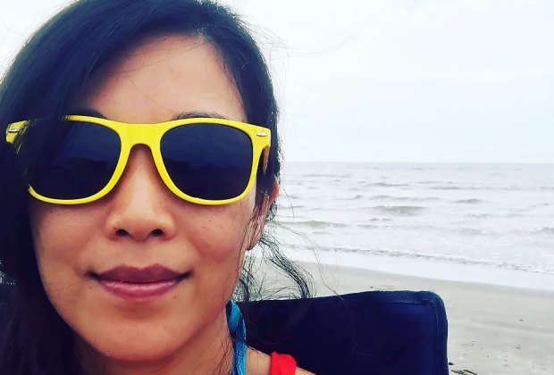 woman in bright yellow sunglasses on the beach