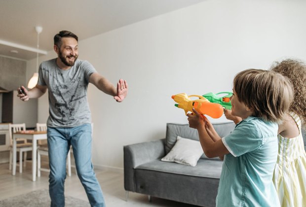 Dad has water gun fight in the house with kids as an example of permissive parenting.