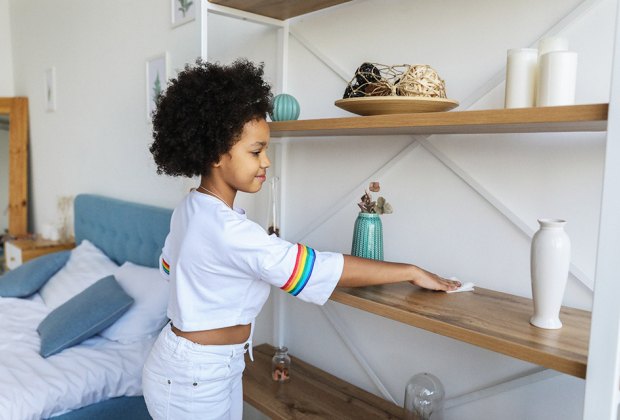 a girl dusting a shelf