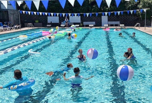 Photo of kids playing games in a large swimming pool.