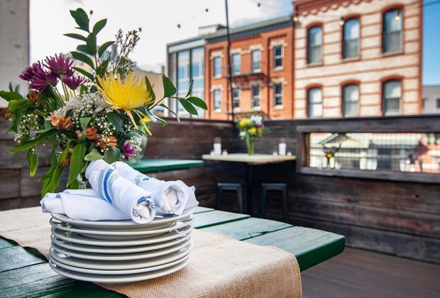 Table with plates on the rooftop patio at Porta