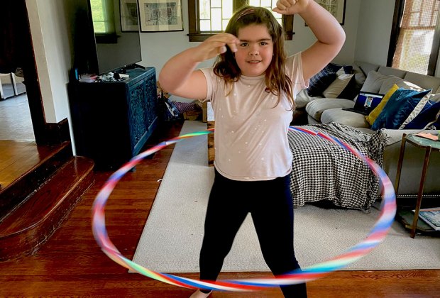 girl hula hoops inside indoors