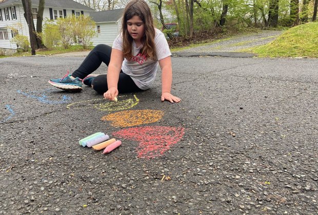 girl drawing with chalk on the sidewalk