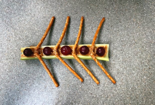 Olympic rowers snack with celery boat, grape people, and pretzel oars held together with peanut butter.