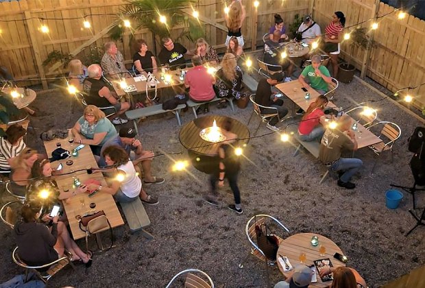 outdoor dining with in a restaurant backyard with string lights strewn above