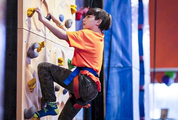 Image of child climbing rock wall at Urban Air Adventure Park in Connecticut.