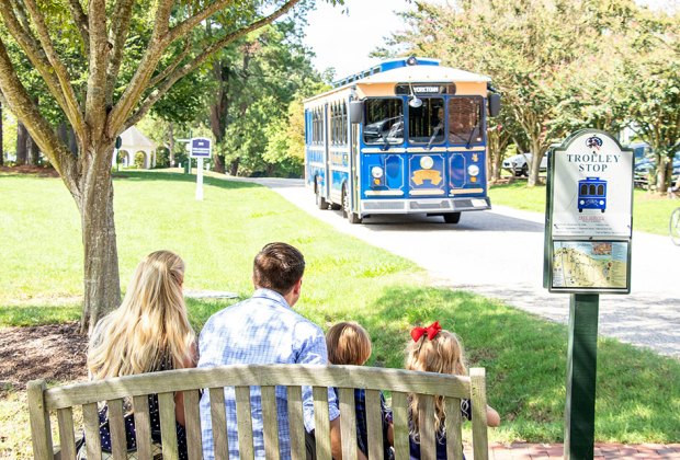 Things To Do in Williamsburg, VA with Kids: Family waiting for trolley in historic Yorktown