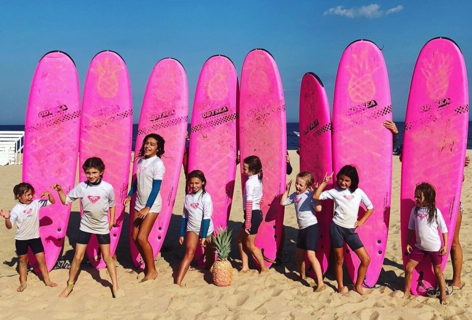Birthday party goers pose in front of Pink Pineapple Surfboards