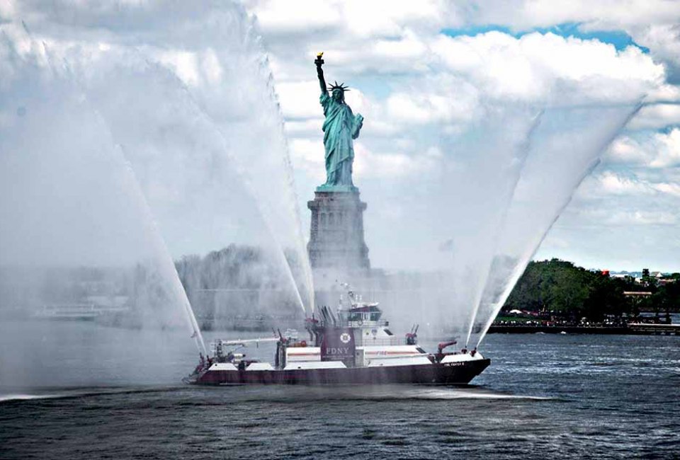 A New York City Fire Department vessel honors the Statue of Liberty with a water salute for Fleet Week. Photo courtesy of Fleet Week New York