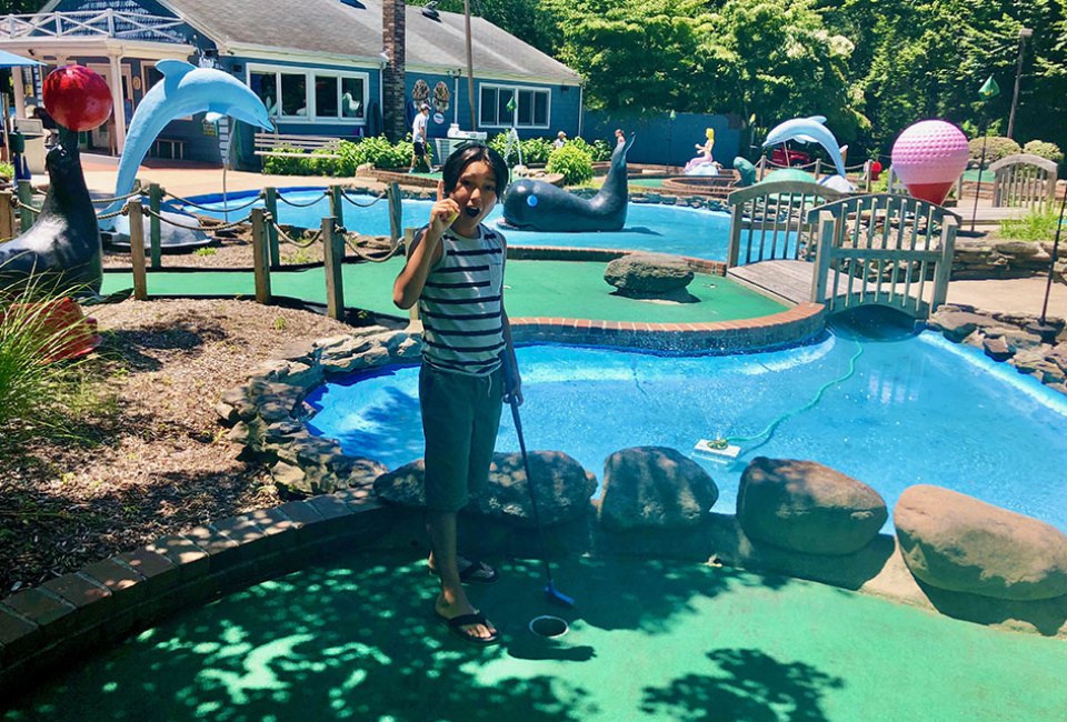 Boy on a mini-golf course in summer sunshine