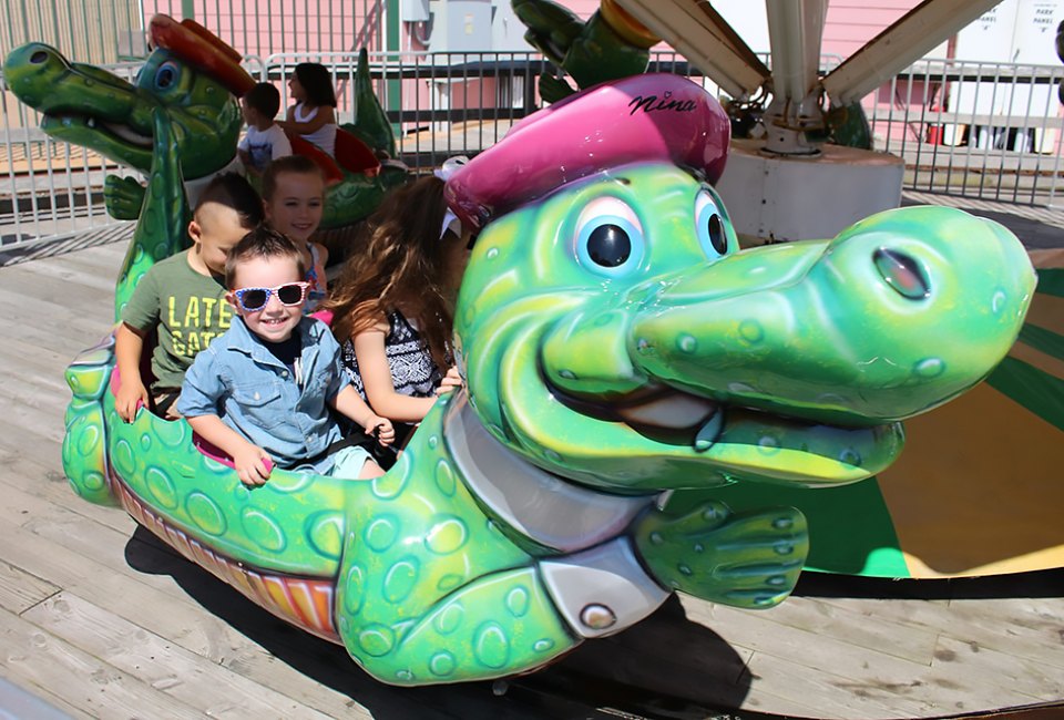 Smiling preschoolers ride the alligator at Jenkinson's