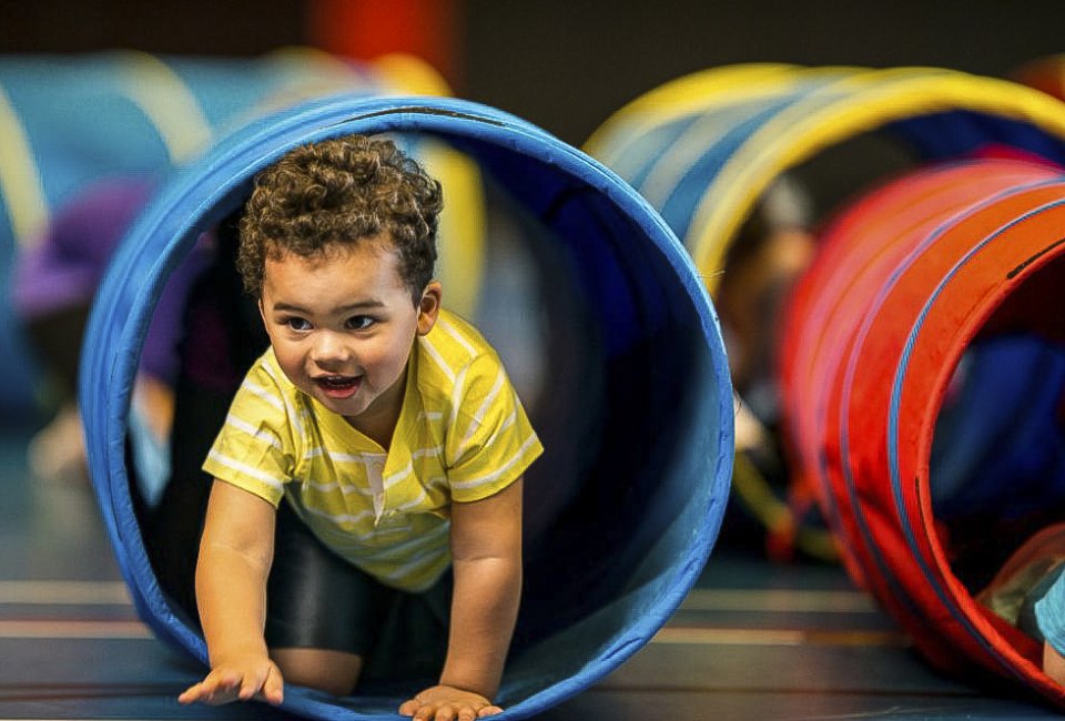 Baby crawling through tunnel. Photo courtesy of Canva