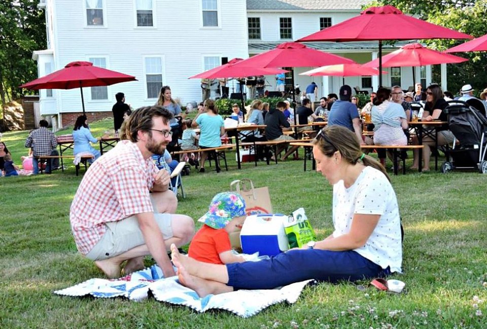 Boston Breweries: Image of a family relaxing in the grass at a Notch Brewery beer garden.