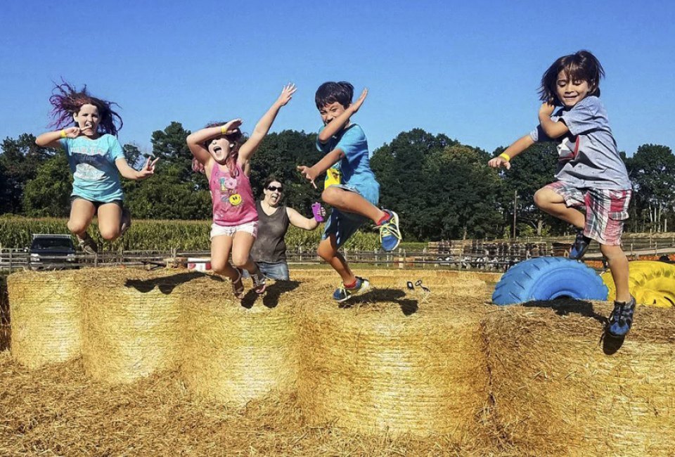 Photo of children jumping on hay bales at a corn maze near Boston.