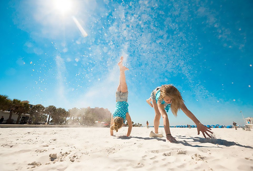 girls doing handstands on the beach