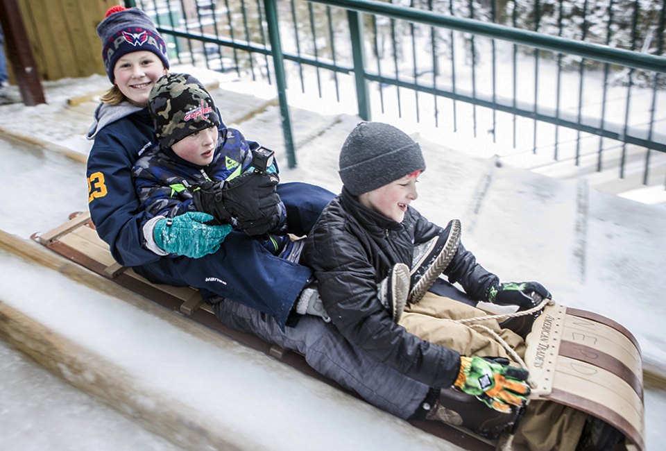 The 30-foot high Lake Placid Toboggan Chute sends riders down an ice-covered slide onto frozen Mirror Lake. 
