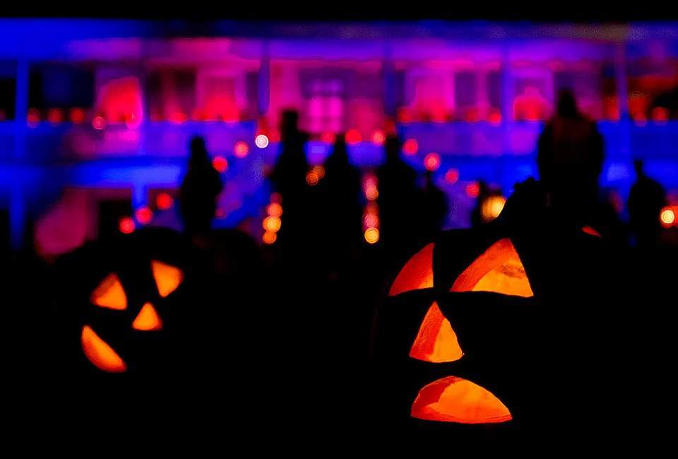 Jack-0'-lanterns line the lawn in front of the manor house. 