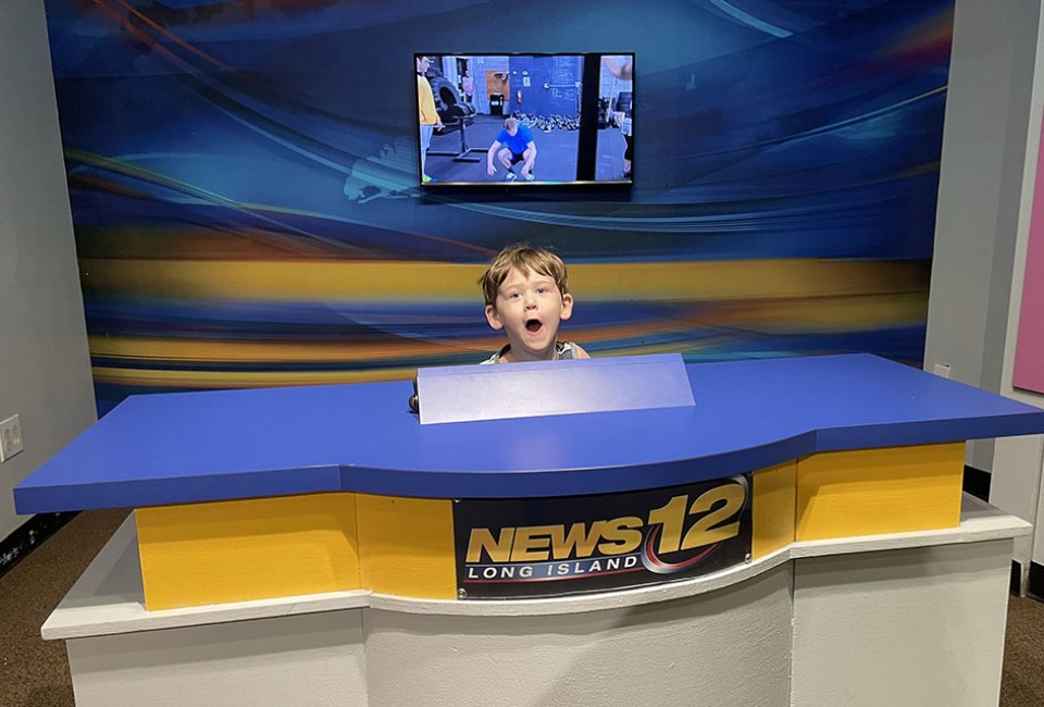 boy sitting at a news desk at LICM