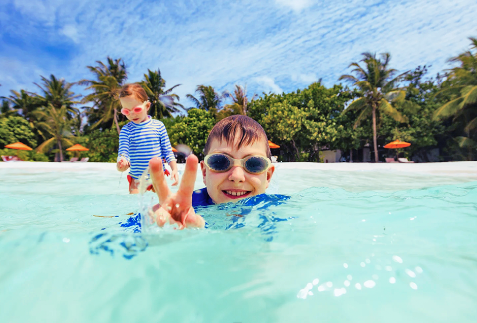 A  shallow, crystal-clear Maldives lagoon is the perfect place for kids to swim. 