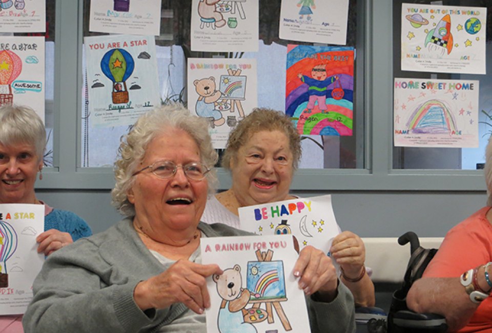 Senior citizens smile after receiving their Color A Smile cards