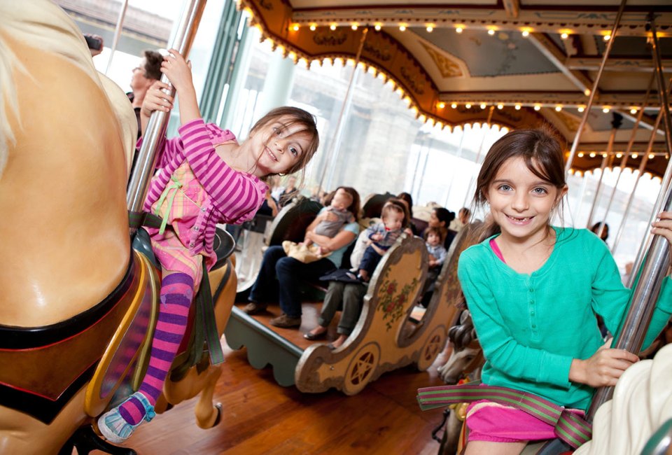 NYC park attractions, like Jane's Carousel in Brooklyn Bride Park, make great, budget-friendly spots to host a birthday party. Photo courtesy of the carousel