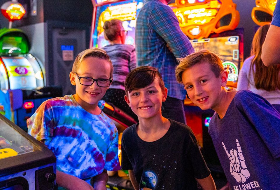Three boys having fun at an arcade. Photo courtesy of Laser X in Addison